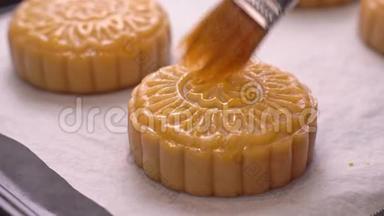 <strong>中秋节制作</strong>月饼的过程-妇女在烘焙前在糕点表面刷蛋液。 节日自制
